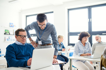 Group of senior people attending computer and technology education class.