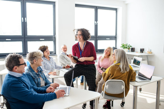 Group of senior people attending computer and technology education class.