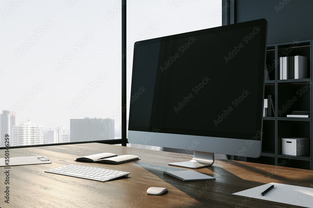 Poster designer workplace with empty black computer screen and city view.