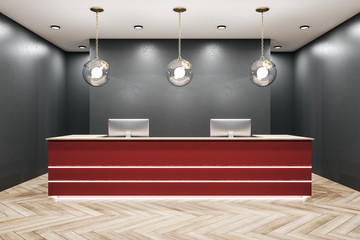 Modern red reception table with two computers.