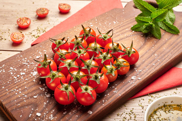 Healthy foods, cherry tomatoes on a wood cutting table.