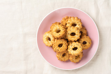 Shortbread in a pink ceramic plate on a light table. A plate of cookies on the table close-up. Top view with space for text
