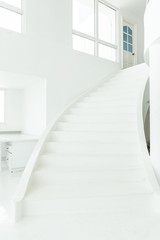 front view of white indoor cement stone staircase without railing in minimal building