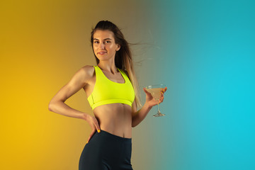Fashion portrait of young fit and sportive caucasian woman on gradient background. Fit sportswoman posing, looks confident. Perfect body ready for summertime. Beauty, resort, sport concept.
