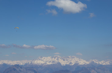 Paraglider field in the sky against the background of the Alpine mountains