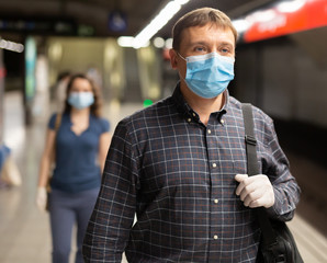 Man in medical mask waiting for subway train