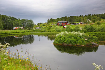 Beautiful landscape along with waters edge, with a village & church & mountains in the background, Saltstraumen, Municipality of Bodo, Nordland county, Norway.