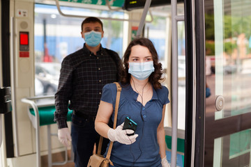 Brunette in medical mask getting off tram