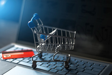 grocery cart on a computer keyboard and credit card on the background of an online store close-up