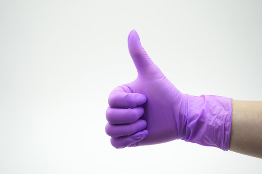 Medical, latex, nitrile glove on a white background shows the thumbs up sign class, cool, success. Laik