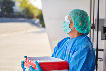 Chirurg bei Organtransport für Operation hält inne vor Klinik