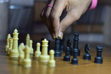 two people playing chess on wooden table, with shallow depth of filed, life during lock down India, stay home stay safe
