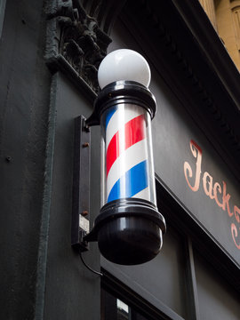 London, St Paul's, UK. May 16th 2020: Jack the clipper, barber shop, hair salon. Barbers pole with red, blue and white turning spiral. The Award Winning London Barbers. Temporarily closed, lockdown.