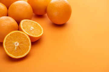 ripe delicious cut and whole oranges on colorful background