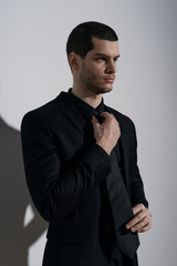 Young handsome businessman in black shirt and black suit. Confident young businessman posing on...