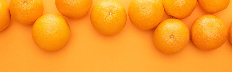 top view of ripe juicy whole oranges on colorful background with copy space, panoramic shot
