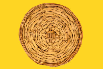 Isolated round stand created by intertwining vines on a yellow background. The view from the top.