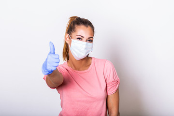Woman with protective mask showing thumb up, and looking at camera. Woman with face mask protection of Coronavirus in human lungs. MERS-CoV, SARS, Adenoviruses and other respiratory viruses