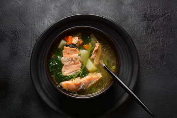 Fresh fish soup on black background