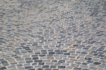 Brick stone street pavement close up background. Empty dark stone pavement on old town ancient street, abstract cobblestone paved road pattern