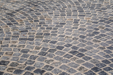 Brick stone street pavement close up background. Empty dark stone pavement on old town ancient street, abstract cobblestone paved road pattern