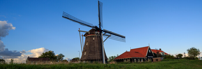 Panoramic view on countryside with old buildings and windmill in the netherlands