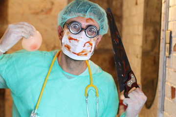 Spooky plastic surgeon holding silicon implants 