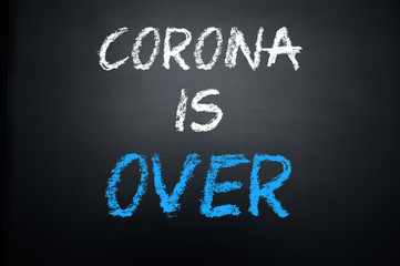 CORONA IS OVER, text written by chalk on black school board