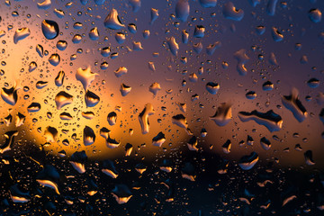 Raindrops on the windowpane in the light of the setting sun.