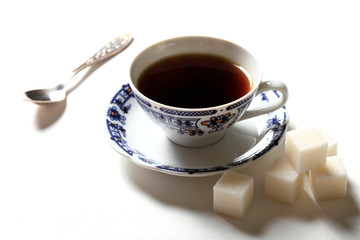 Cup of coffee and pieces of sugar on a white background
