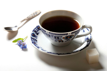 Morning cup of coffee and a piece of sugar on a white background