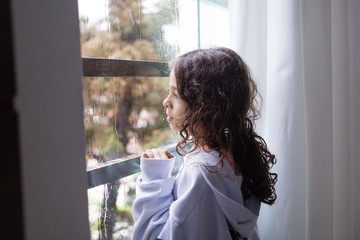 young woman looking out window