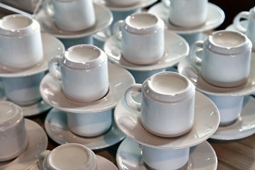 Clean coffee cups stack in a cafe, no guests