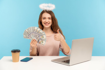 Excellent rich life, I like big money! Lovely angelic woman with nimbus sitting at laptop, holding...