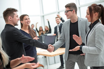 business partners shaking hands to the applause of the working group