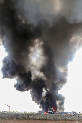 Fototapeta na wymiar Big column of smoke coming from a burning cars