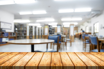 Empty wooden desk space platform with library background for product display montage. Education concept.