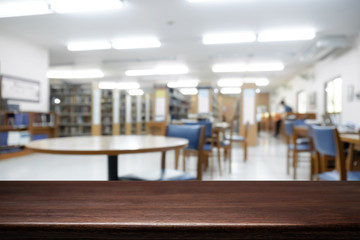 Empty wooden desk space platform with library background for product display montage. Education concept.