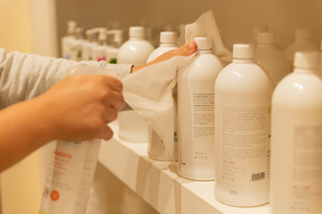 Female caucasian shop assistant cleaning products with hydroalcoholic gel. New normal coronavirus...