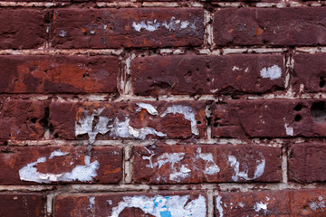 red brick wall with scraps of ads