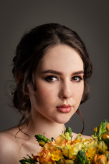 Fototapeta premium Bride in white dress with bouquet in photostudio