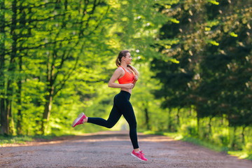 Young attractive sport girl running in park, girl in sporty runn