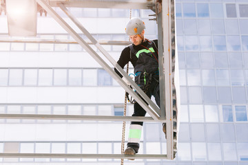 Industrial climber in helmet and overall working on height. Risky job. Professional worker