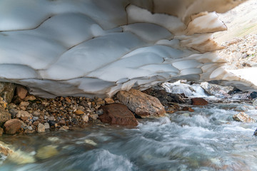The beautiful view of frozen glacier and Kaznok river neat to Zmeya peak in Fann mountains in Tajikistan