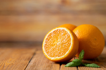 Three fresh oranges on a wooden table