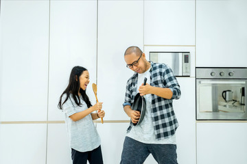 Child and father having fun with kitchenware