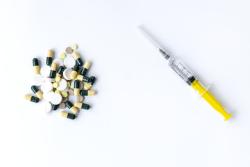 
syringe and pills on a white background