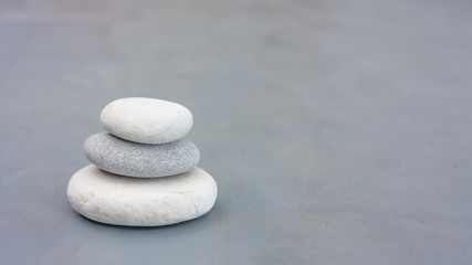 Fototapeta na wymiar Tree grey roundstones on clear gray background. Spa stones, zen like concept. Pastel colors