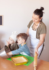 happy mom prepares a pie with children, entertains children on maternity