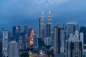 Fototapeta na wymiar Panoramic view of Kuala Lumpur skyline at night time. City center of capital of Malaysia. Illumination lights contemporary buildings exterior with glass.